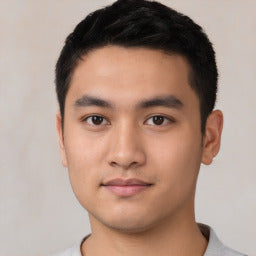 Close-up of a person with a neutral expression on a plain background