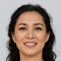 Woman with dark hair and a neutral background