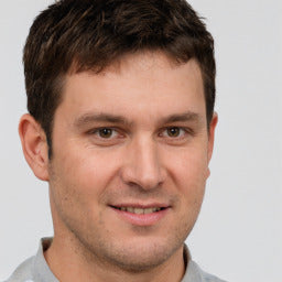 Man wearing a gray shirt with a neutral background